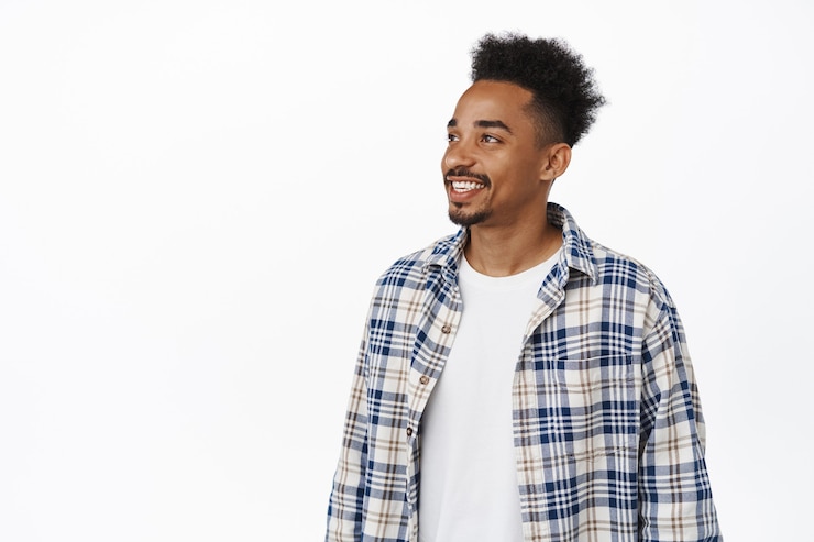Photo gratuit portrait d'un homme hipster moderne avec une coiffure afro et une moustache, regardant de côté la bannière de vente, regardant à gauche et souriant heureux, regardant quelque chose d'intéressant, texte promotionnel sur un espace vide