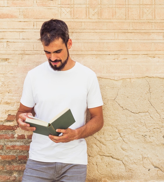 Portrait d&#39;un homme lisant un livre devant un vieux mur