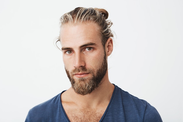 Portrait d'un homme mal rasé nordique avec une coiffure à la mode posant