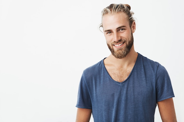 Portrait d'un homme mal rasé nordique avec une coiffure à la mode posant