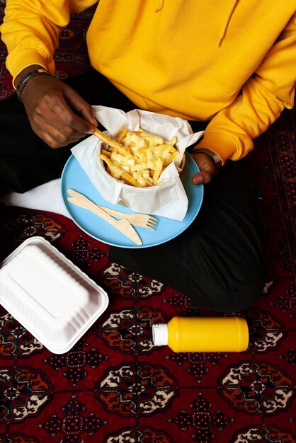 Portrait d'homme mangeant un délicieux plat de poutine