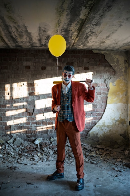 Portrait d'homme avec maquillage de clown effrayant et ballon