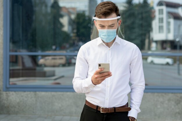 Portrait homme avec masque à l'aide de mobile