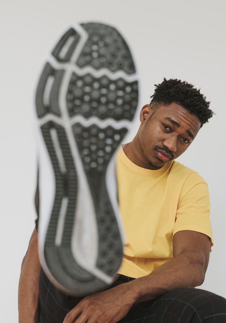 Photo gratuit portrait d'homme montrant la chaussure