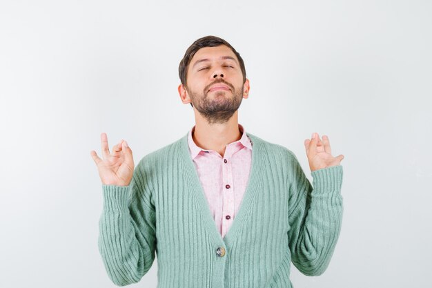 Portrait d'homme mûr montrant un geste correct en chemise, cardigan et regardant la vue de face focalisée