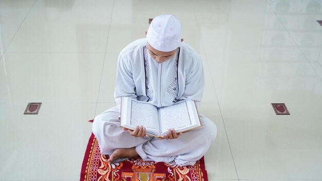 Un portrait d'un homme musulman asiatique tenant le coran