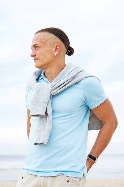 Portrait d'homme sur la plage en t-shirt bleu