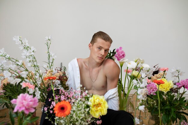 Portrait d'homme posant avec des fleurs