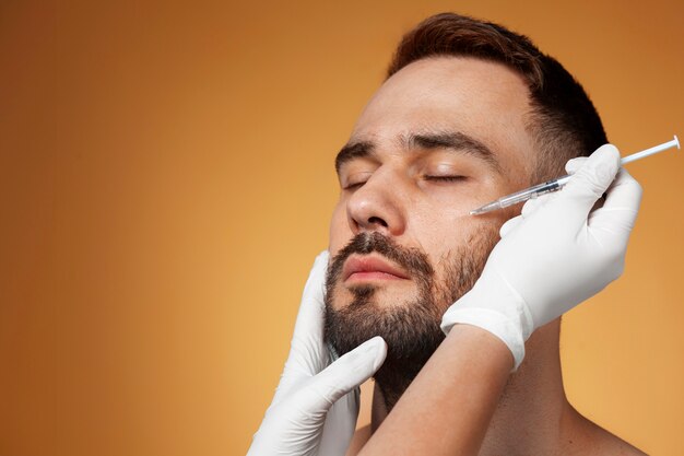 Photo gratuite portrait d'un homme recevant des améliorations et des ajustements à l'aide de procédures cosmétiques.