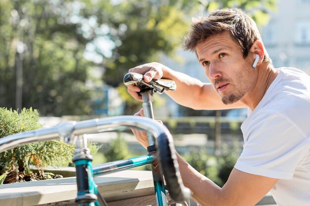 Portrait d'homme réparant son vélo à l'extérieur