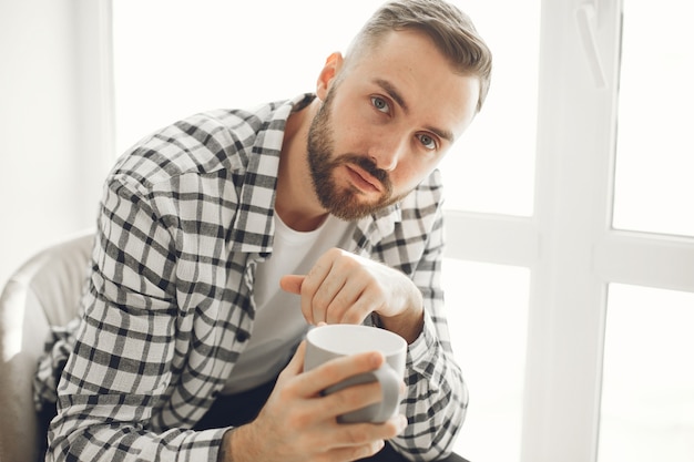 Portrait d'homme se détendre à la maison avec une tasse de café