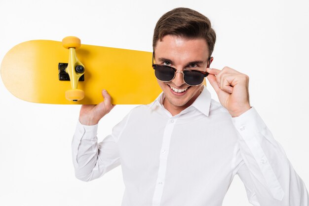 Portrait d'un homme séduisant en chemise blanche et lunettes de soleil