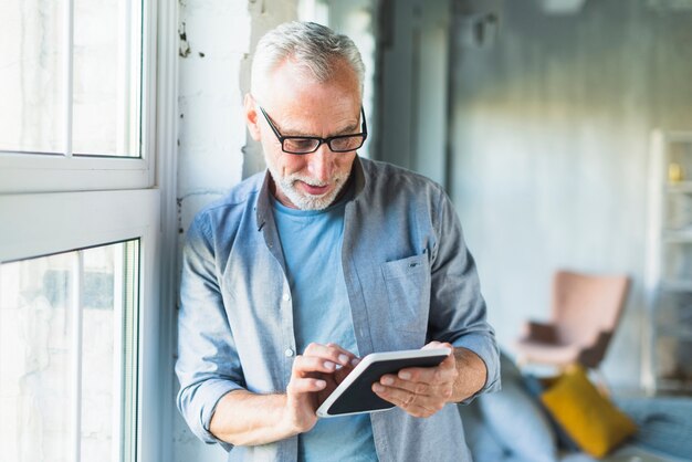 Portrait d&#39;un homme senior à l&#39;aide de tablette numérique