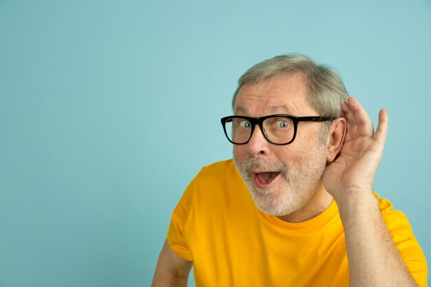 Portrait de l'homme senior caucasien isolé sur studio bleu