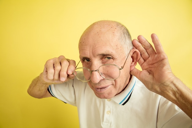 Portrait de l'homme senior caucasien isolé sur studio jaune