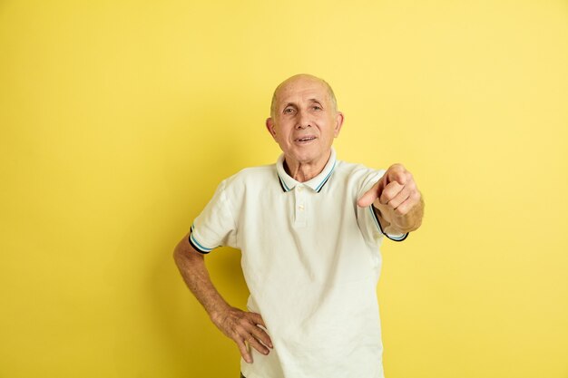 Portrait de l'homme senior caucasien isolé sur studio jaune