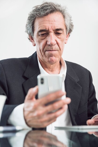 Portrait d&#39;homme senior en regardant smartphone