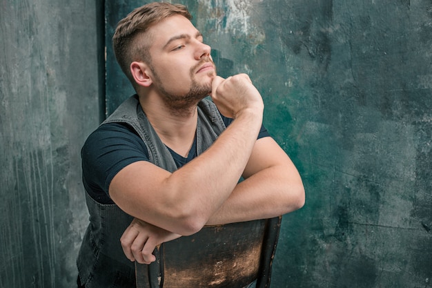 Portrait d'un homme sérieux assis sur la chaise