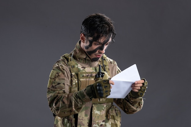 Portrait d'homme soldat en tenue de camouflage lettre