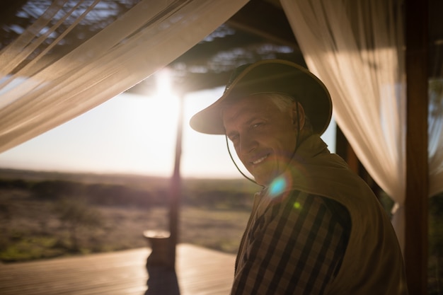 Portrait d'un homme souriant assis sur un lit à baldaquin