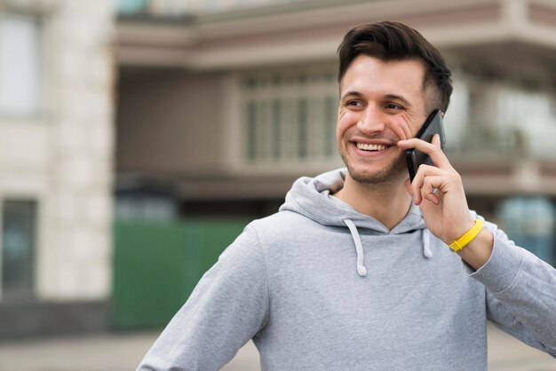 Portrait d'un homme souriant, parler au téléphone