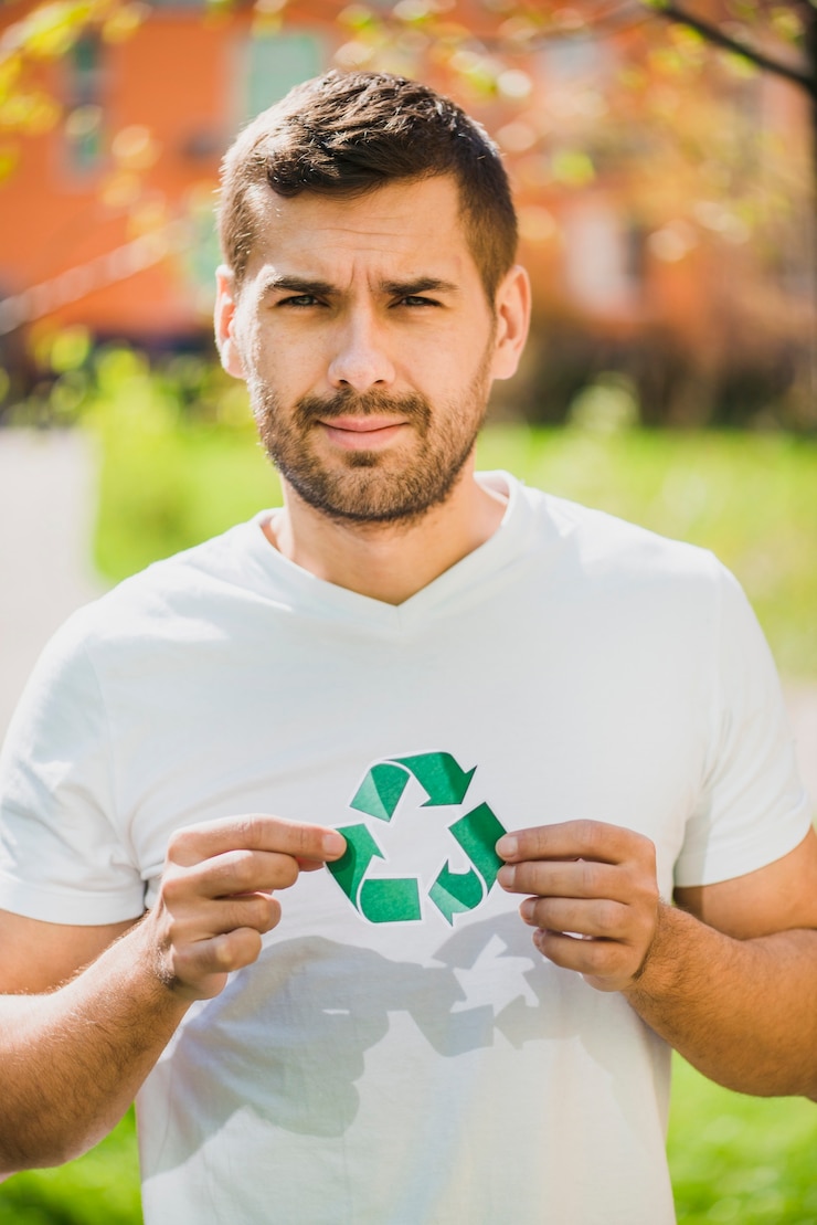 Photo gratuit portrait d&#39;un homme souriant, tenant l&#39;icône du recyclage dans le parc