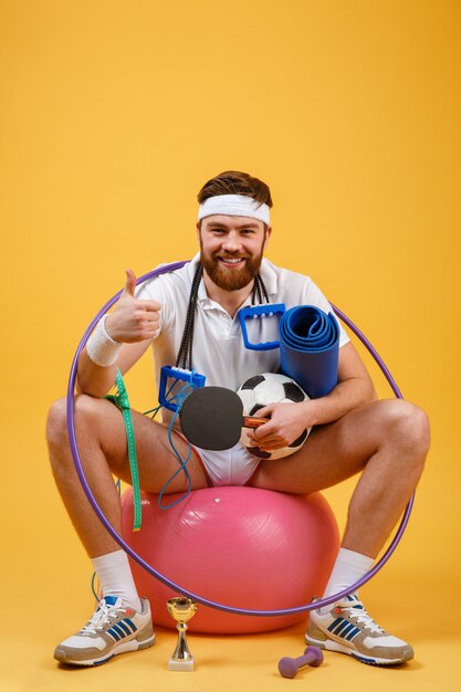 Portrait d'un homme de sport assis sur un ballon de fitness