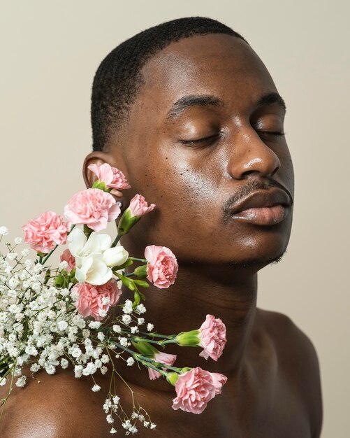 Portrait d'homme torse nu posant avec bouquet de fleurs