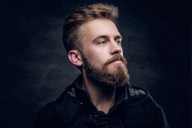 Portrait d'un homme urbain barbu isolé avec éclairage de contraste sur fond gris vignette.