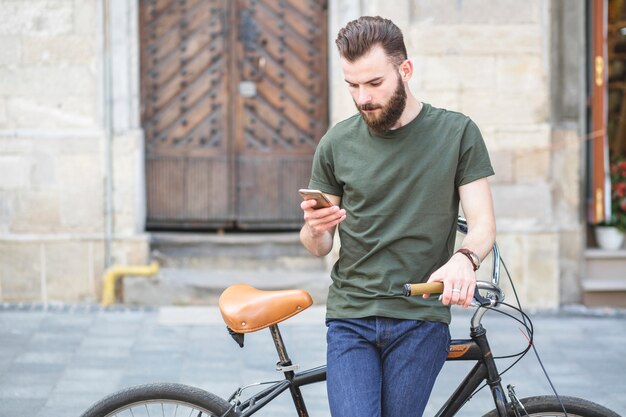 Portrait, homme, vélo, debout, téléphone portable