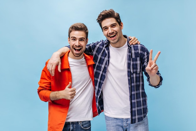 Portrait d'hommes bruns charmants en t-shirts blancs et jeans sur isolé