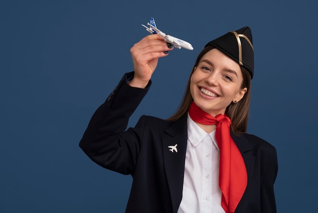 Photo gratuite portrait d'hôtesse de l'air avec figurine d'avion