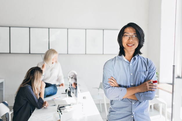 Portrait intérieur d'employés internationaux avec un homme asiatique souriant au premier plan