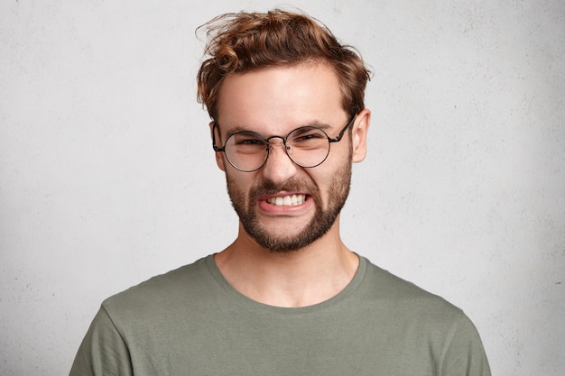 Portrait intérieur de jeune homme barbu avec une coiffure à la mode