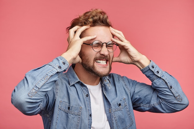 Portrait intérieur de jeune homme barbu avec une coiffure à la mode