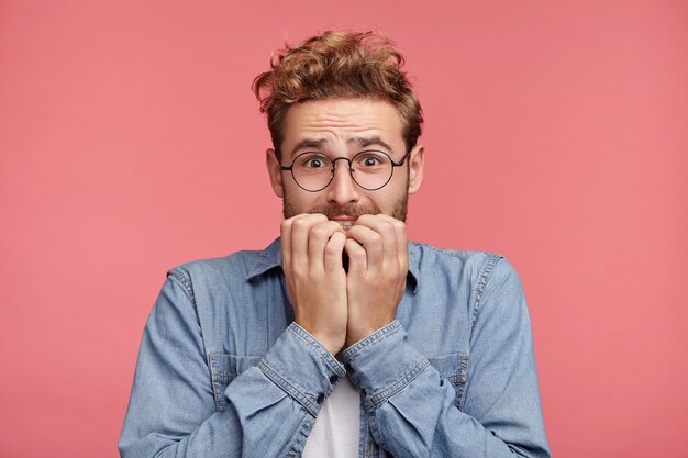 Portrait intérieur de jeune homme barbu avec une coiffure à la mode