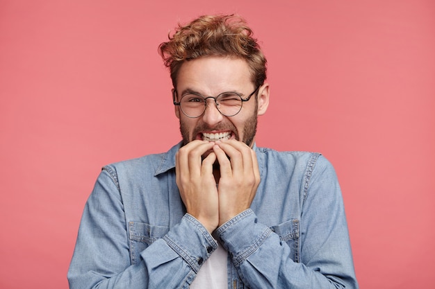 Portrait intérieur de jeune homme barbu avec une coiffure à la mode