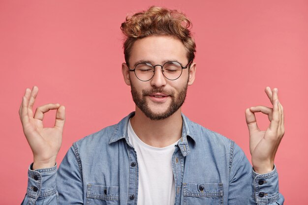 Portrait intérieur de jeune homme barbu avec une coiffure à la mode