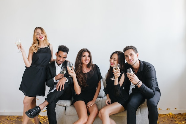 Portrait intérieur de jeunes heureux avec des verres de champagne