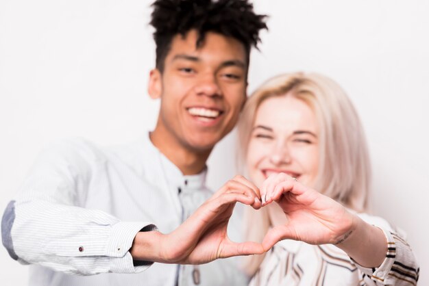 Portrait, de, interracial, couple, sourire, forme coeur, à, leurs, mains