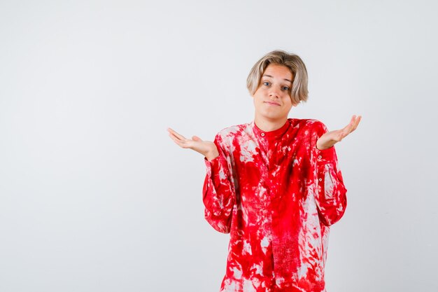 Portrait de jeune adolescent montrant un geste impuissant en chemise et à la vue de face confuse