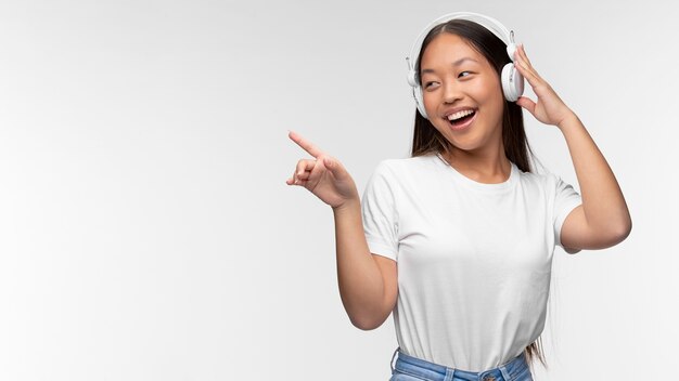 Portrait de jeune adolescente avec des écouteurs écoutant de la musique