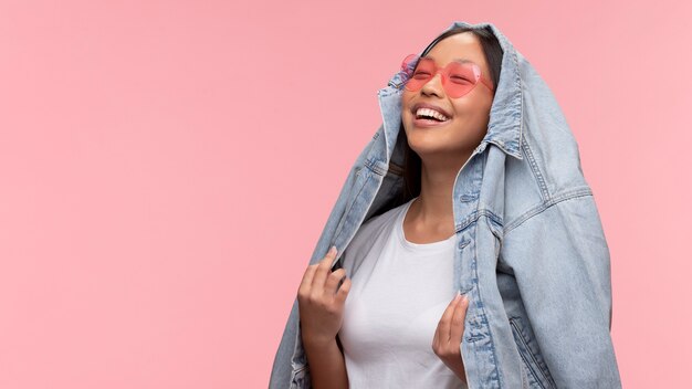 Portrait de jeune adolescente avec des lunettes de soleil et une veste en jean