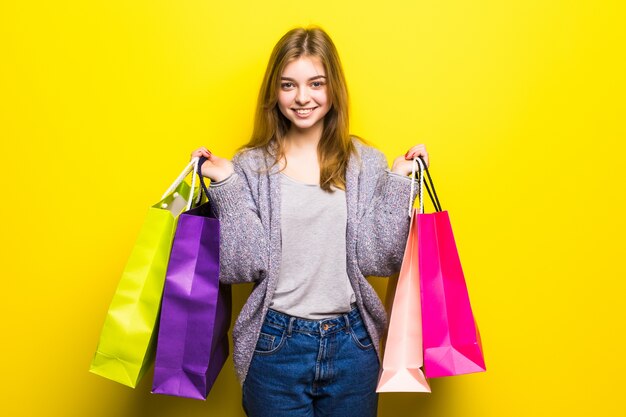 Portrait de jeune adolescente souriante heureuse avec des sacs à provisions, isolé