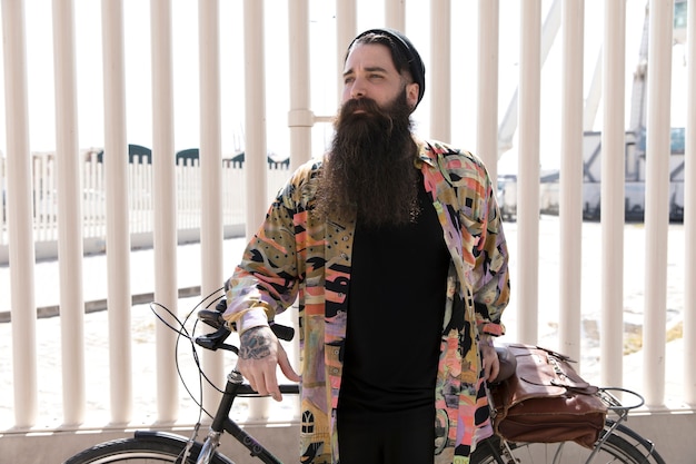 Portrait, jeune, barbe longue, debout, bicyclette, devant, clôture