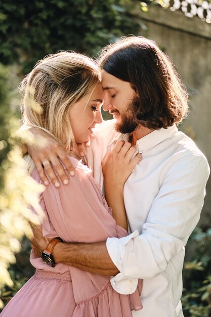 Portrait de jeune beau couple romantique s'embrassant sensuellement à un rendez-vous en plein air