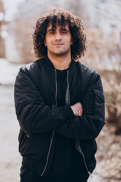 Photo gratuite portrait de jeune bel homme aux cheveux bouclés