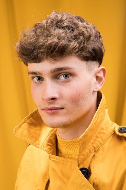 Portrait de jeune bel homme dans une scène jaune