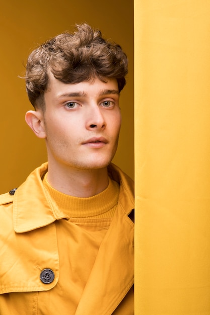 Photo gratuite portrait de jeune bel homme dans une scène jaune