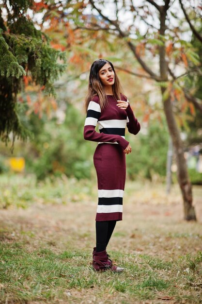 Portrait de jeune belle adolescente indienne ou sud-asiatique en robe posée au parc d'automne en Europe